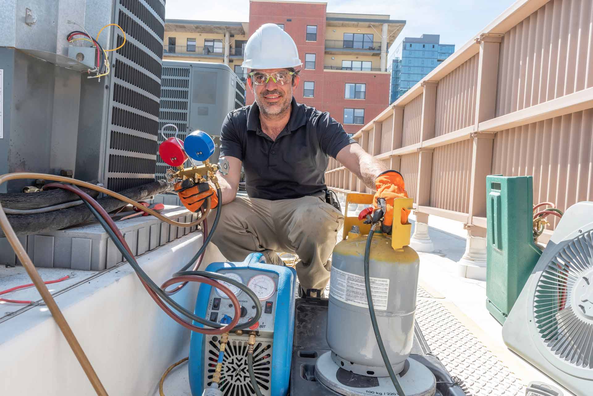 hvac tech refilling refrigerant in outdoor unit